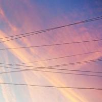 câbles d'alimentation électrique et nuages roses au coucher du soleil photo