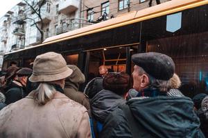 de nombreuses personnes non identifiées attendent le transport urbain à l'arrêt de bus photo