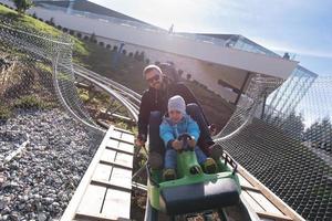 père et fils aime conduire sur les montagnes russes alpines photo