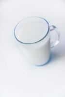 lait dans un verre en verre sur fond blanc. un beau verre de lait. photo