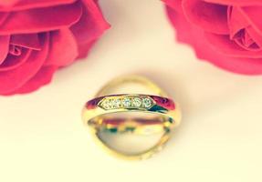 roses rouges et anneaux d'or sur blanc photo