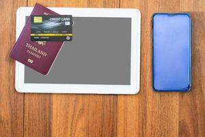 passeport vue de dessus avec carte de crédit et tablette numérique maquette sur un bureau en bois photo