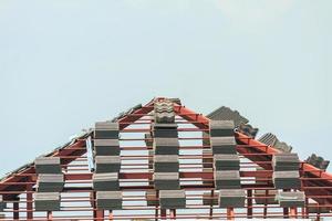 construction de maison sur le toit avec beaucoup de tuiles prêtes à être installées photo