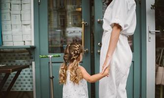 jeune mère et jolie petite fille marchant dans la rue photo