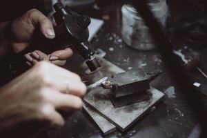 dans l'atelier, une bijoutière s'affaire à souder des bijoux photo