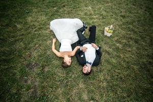 couple de mariés allongé sur l'herbe photo