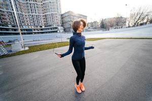 jeune femme exercice avec corde à sauter à l'extérieur photo