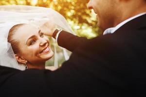 le marié lève le voile de la mariée photo