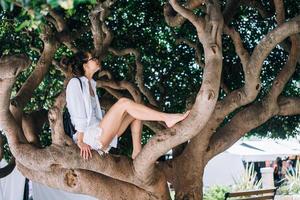 belle femme assise sur un arbre. temps de printemps photo