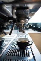 petite tasse d'expresso debout dans la machine à café en acier photo