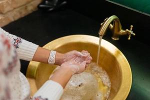 photo en gros plan d'une femme se lave les mains avec de l'eau et du savon.