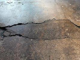 sol en béton fissuré cassé au sol de la maison ou de la route de la rue s'affaisser du tremblement de terre photo