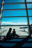 petit garçon et sa mère assis dans un aéroport photo