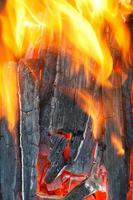 flamme au-dessus du bois de chauffage brûlant photo