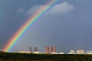 arc-en-ciel dans le ciel gris au-dessus de la ville avec tour de télévision photo