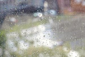 gouttes de pluie sur la vitre et la rue urbaine floue photo