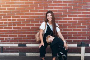mère et jeune fils posant sur fond de mur de briques photo