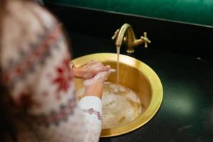 photo en gros plan d'une femme se lave les mains avec de l'eau et du savon.