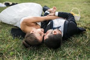 couple de mariés allongé sur l'herbe photo