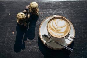 café café dans une tasse blanche avec un motif de feuilles photo