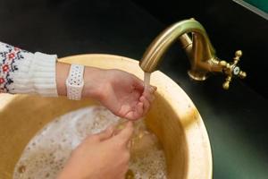 photo en gros plan d'une femme se lave les mains avec de l'eau et du savon.