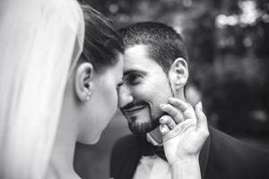 belle mariée caresse doucement, le visage du marié photo