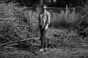 l'homme aux bottes authentiques et aux jeans selvedge sur fond de branches photo