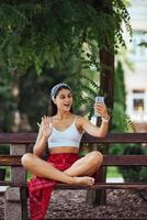 femme utilisant un smartphone dans un parc assis sur un banc photo