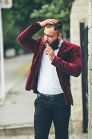 un homme riche avec une barbe fume une cigarette électronique photo