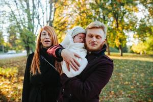 jeune famille et fils nouveau-né dans le parc d'automne photo