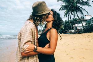 un mec et une fille s'embrassent sur la plage photo