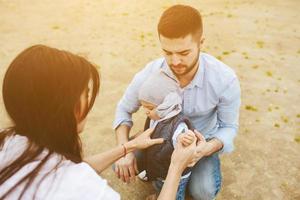 jeune famille heureuse avec un petit garçon dans la nature photo