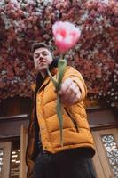 bel homme a une fleur, tulipe rose à petite amie photo