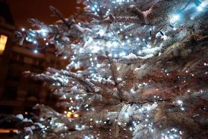 arbre de noël avec des cônes dans une rue de la ville illuminée d'une guirlande. photo