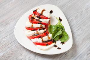 fromage mozzarella et tomate avec brindille de basilic photo