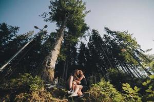 beau couple assis dans une forêt près de l'arbre photo