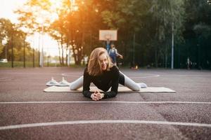 jeune femme en forme de vêtements de sport s'entraîne à l'extérieur sur l'aire de jeux. photo