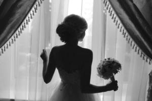 belle mariée en robe de mariée, par fenêtre. photo