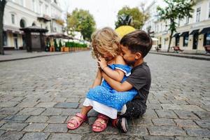 petit garçon et fille sont assis dans la rue photo