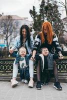 deux mamans et leurs deux garçons posant devant la caméra photo