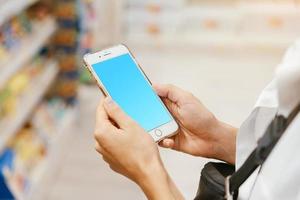 vue rapprochée fille à l'aide de smartphone en magasin. photo