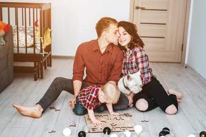 une famille heureuse joue ensemble sur le sol photo