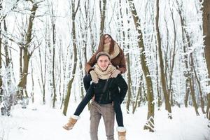 couple heureux jouant ensemble dans le parc à neige photo