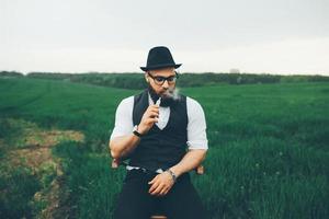 homme à barbe fume une cigarette électronique photo