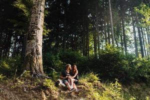 beau couple assis dans une forêt près de l'arbre photo