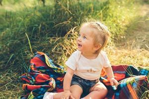 petite fille assise sur la pelouse photo