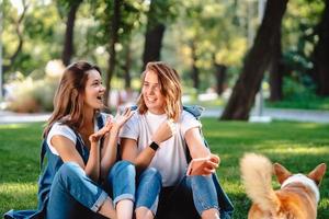 des amis candides assis au parc se parlent. photo