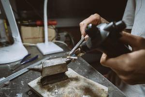 dans l'atelier, une bijoutière s'affaire à souder des bijoux photo