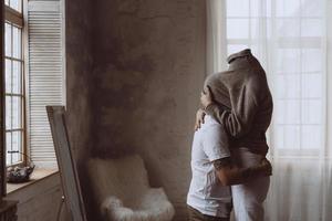 le mec et la fille dans les bras l'un de l'autre dans la chambre photo