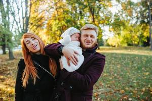 jeune famille et fils nouveau-né dans le parc d'automne photo